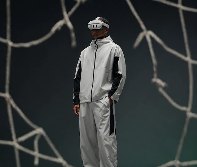 Person wearing a VR headset standing among bare branches