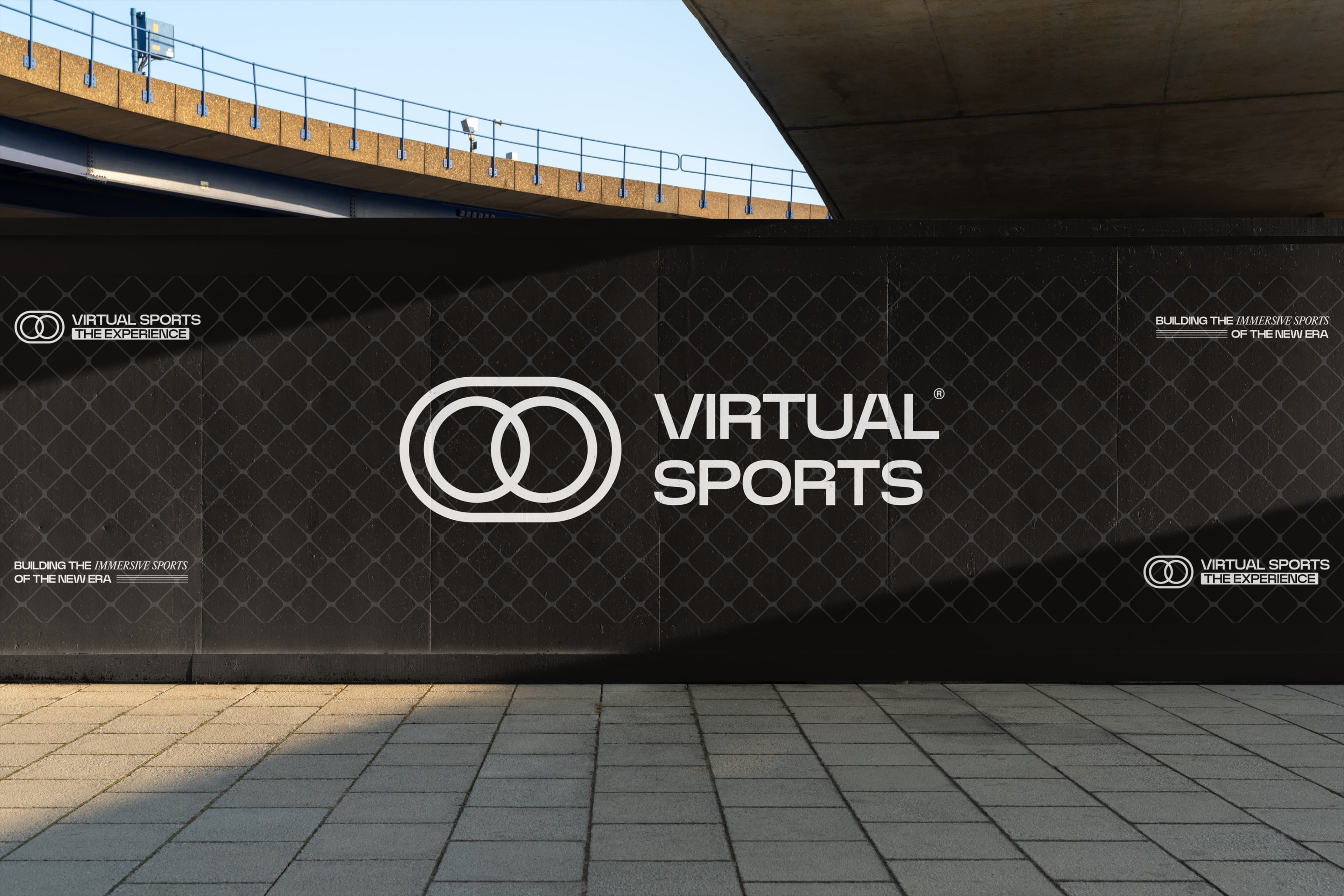 A Virtual Sports branded hoarding running along a wall beneath a concrete flyover