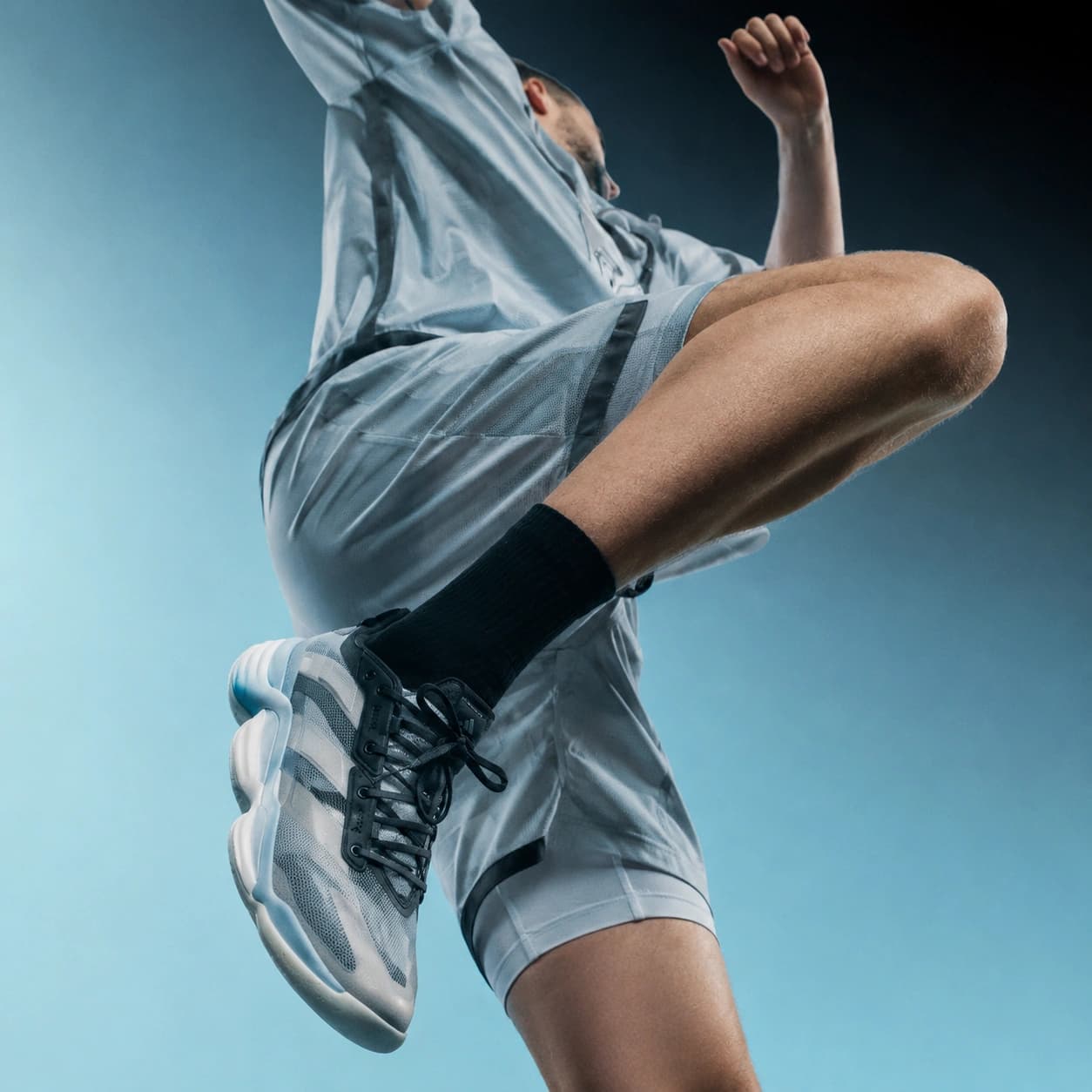 A VSHandball player seen from below at the top of a jump, leg extended